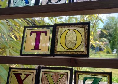Mary Corkery - Lovely Letters – This picture shows a small selection of mini traditional kiln fired stained glass panels – 9cm x 10cm each